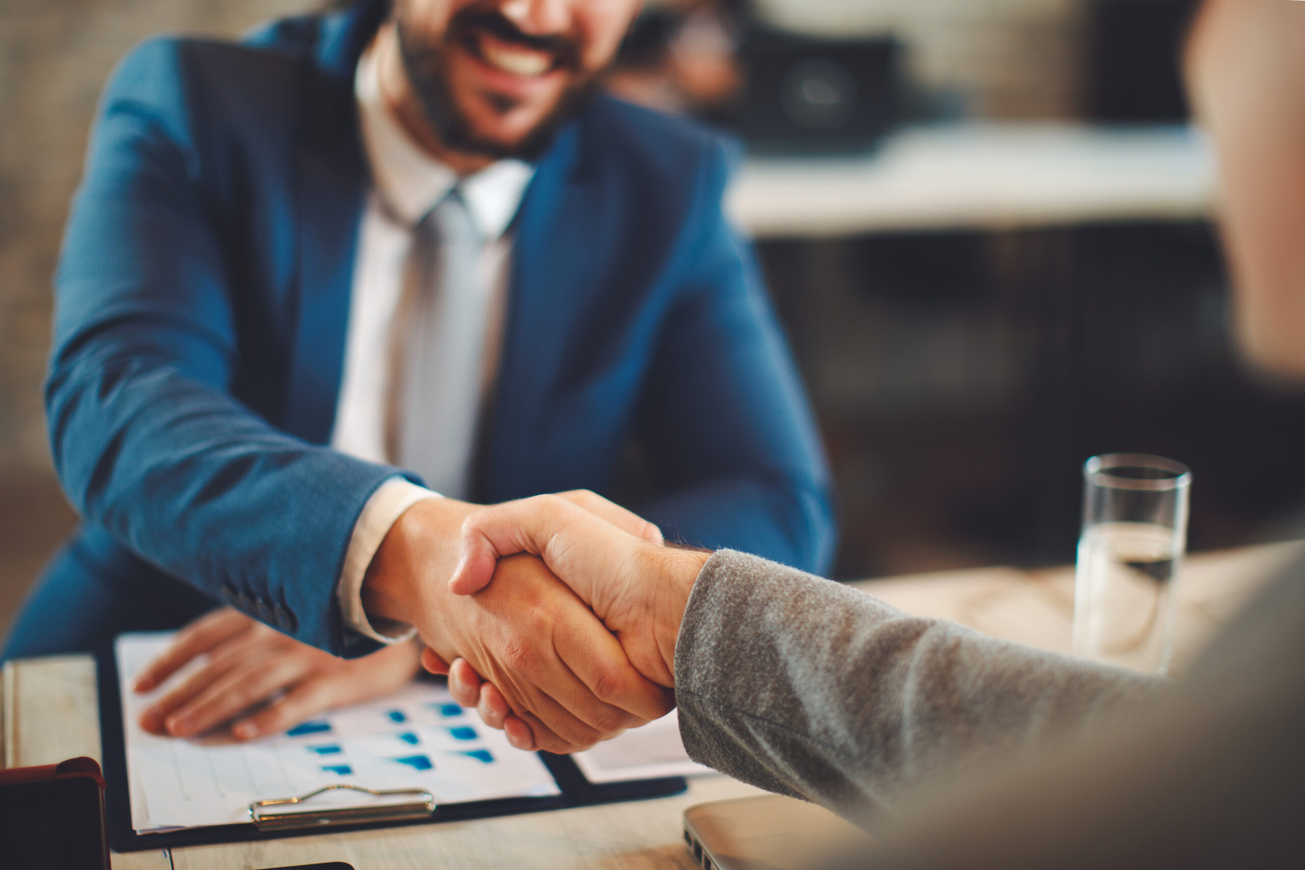 Close up of business handshake in the office. Selective focus on hands