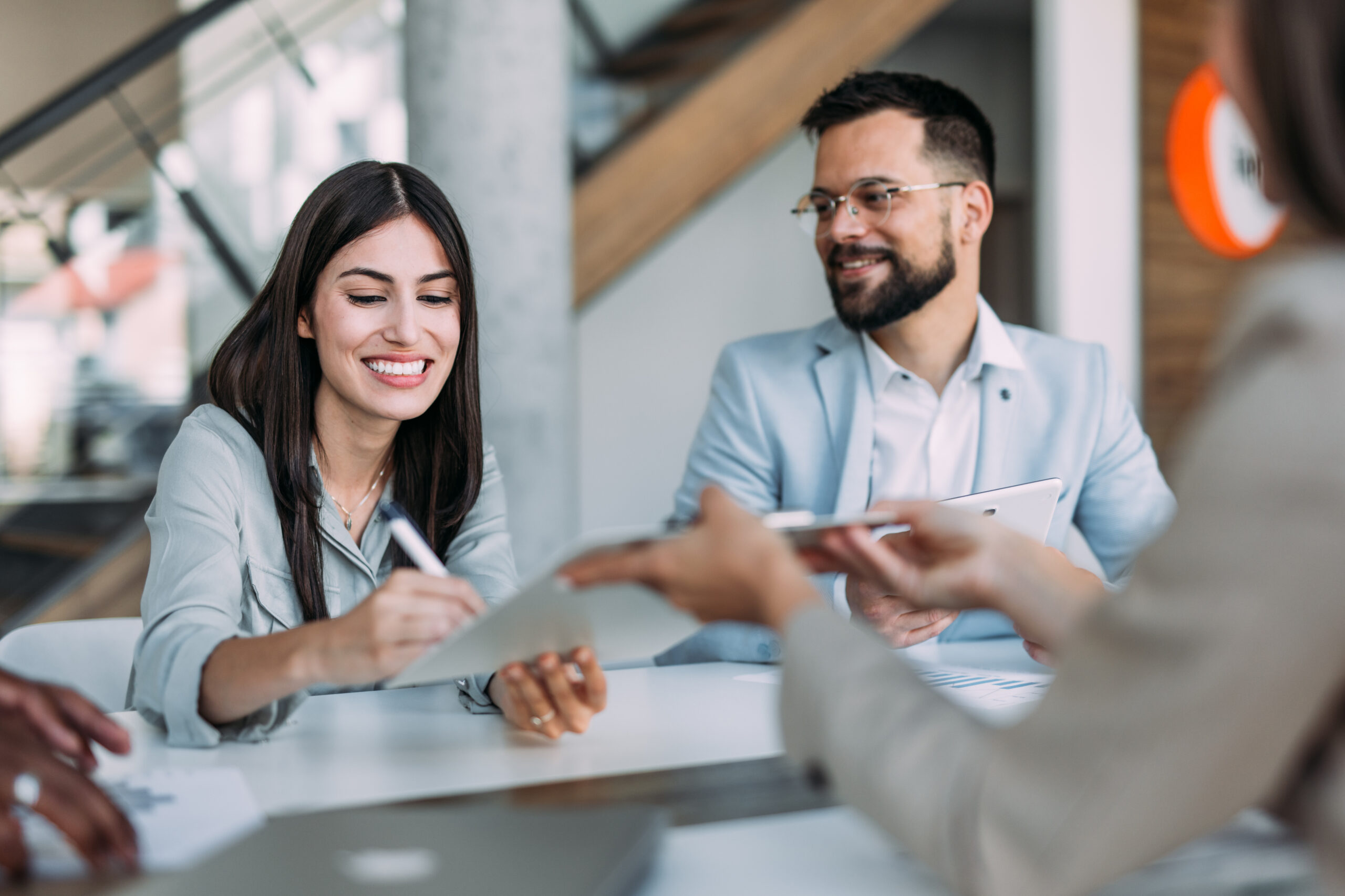 Shot of confident businesswoman filling in paperwork in an office. Business persons signing a document during a meeting in board room.